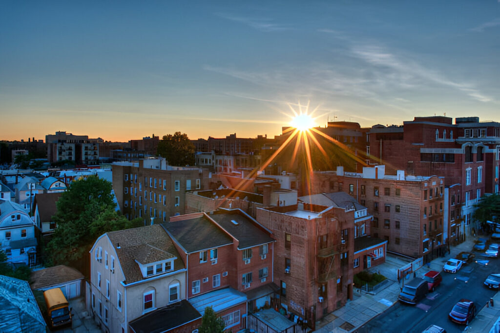Sunset over rooftops in Astoria, Queens, NY – neighborhood served by AZX residential and commercial cleaning